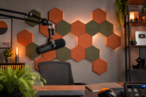 Cenário de home studio de gravação iluminado com painéis de tratamento acústico hexagonais e coloridos na parede de fundo.